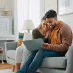 Couple sitting on a couch with a laptop