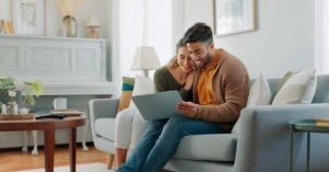 Couple sitting on a couch with a laptop