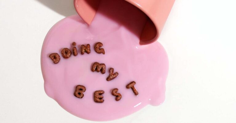 Pink coloured liquid spilled from a mug with alphabet shaped cereal