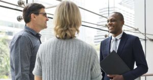 Husband and wife meeting with financial adviser in a suit