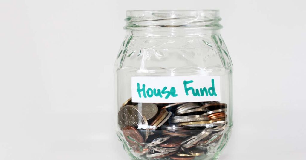 Jar of coins with a sticker that reads house fund