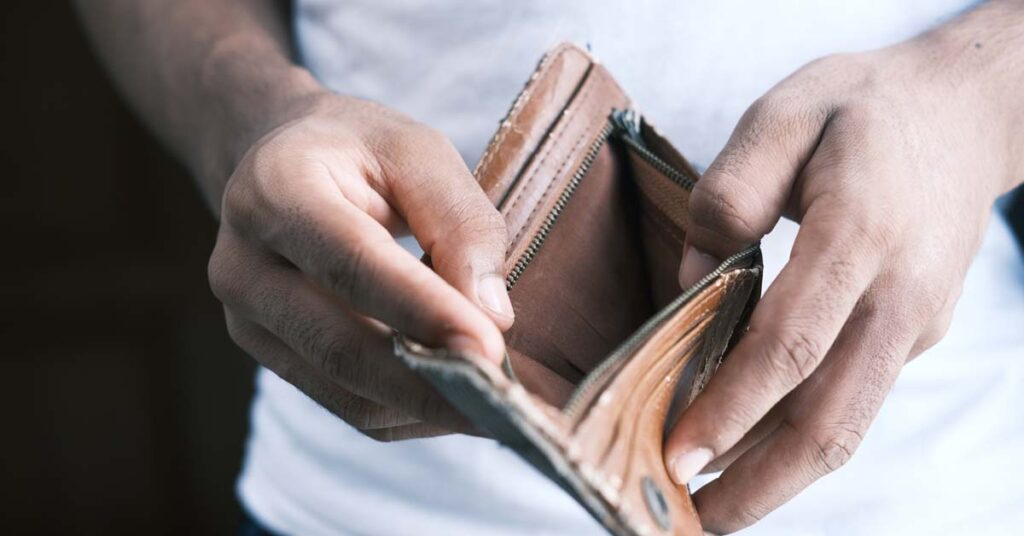Man holding open an empty wallet