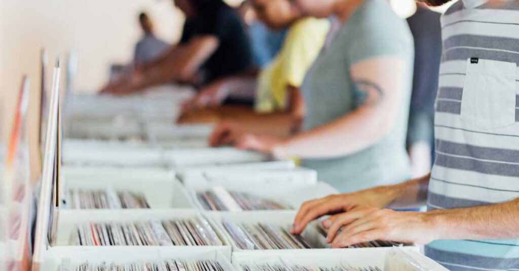 People looking through vinyl records deciding which to buy