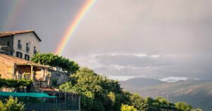 Double rainbow shines over a house during a storm